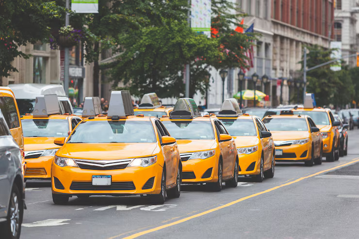 A line of yellow taxis parked on a bustling city street